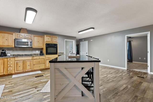 1160 Lucas Rd, Lucedale, MS 39452 - kitchen featuring stainless steel appliances, light wood-type flooring, light brown cabinets, dark countertops, and a textured ceiling