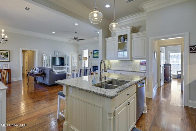 kitchen featuring tasteful backsplash, visible vents, dark wood finished floors, a sink, and stainless steel dishwasher