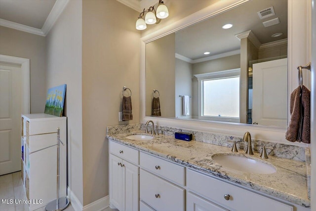 bathroom with double vanity, ornamental molding, a sink, and visible vents