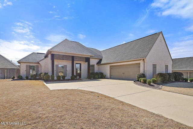 view of front of house with an attached garage, a front lawn, concrete driveway, and brick siding