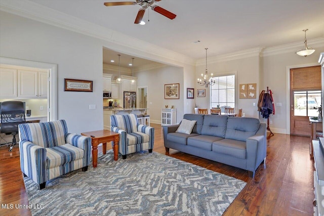 living room featuring dark wood-style floors, ornamental molding, baseboards, and ceiling fan with notable chandelier