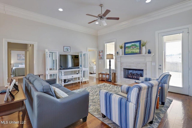 living room featuring ornamental molding, a fireplace, and wood finished floors