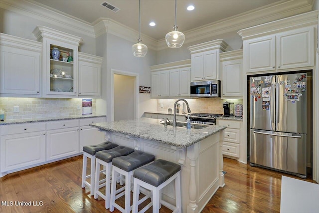 kitchen featuring dark wood-style flooring, visible vents, stainless steel appliances, and a sink