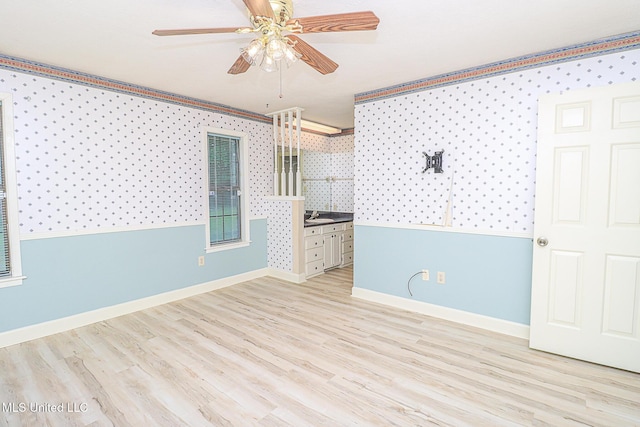 unfurnished room with wallpapered walls, baseboards, a ceiling fan, and wood finished floors