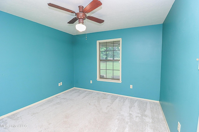 unfurnished room featuring carpet flooring, baseboards, and ceiling fan