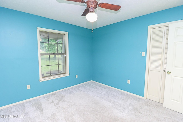 spare room with carpet flooring, ceiling fan, and baseboards