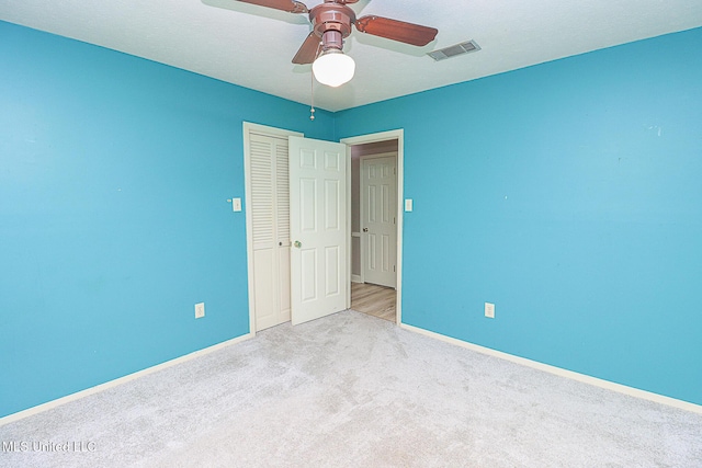 unfurnished bedroom featuring baseboards, carpet, a closet, and ceiling fan