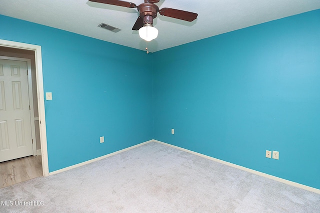 carpeted empty room with ceiling fan and baseboards
