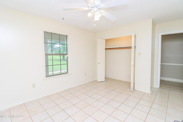 unfurnished bedroom with ornamental molding, a closet, a ceiling fan, and light tile patterned floors