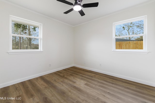 spare room with ceiling fan, crown molding, baseboards, and wood finished floors