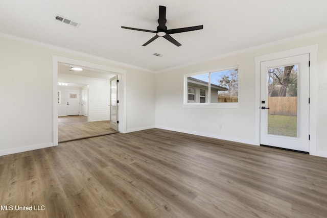 interior space featuring ornamental molding, visible vents, baseboards, and wood finished floors