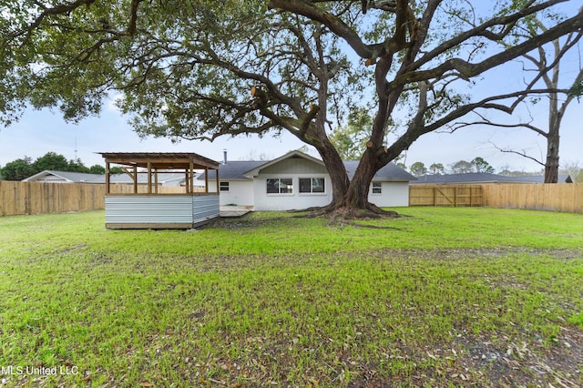 rear view of property with a lawn and a fenced backyard