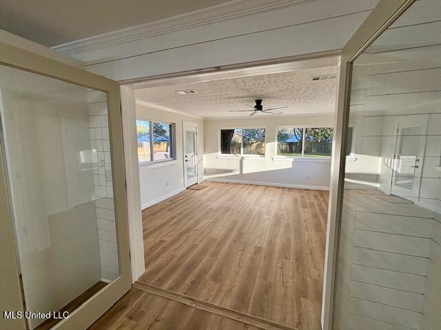 unfurnished sunroom with a healthy amount of sunlight and ceiling fan