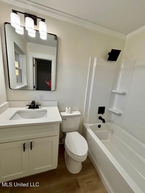 full bathroom with crown molding, bathing tub / shower combination, toilet, vanity, and wood finished floors