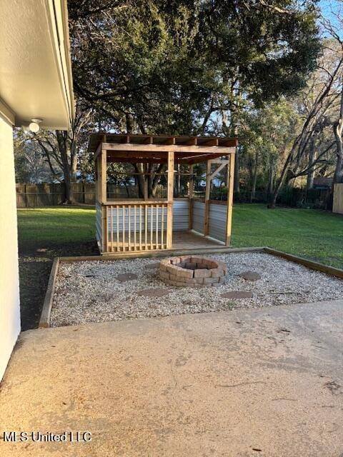 view of yard featuring an outdoor fire pit and fence