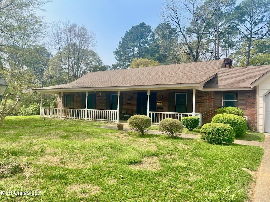 ranch-style home with a porch, a garage, and a front lawn