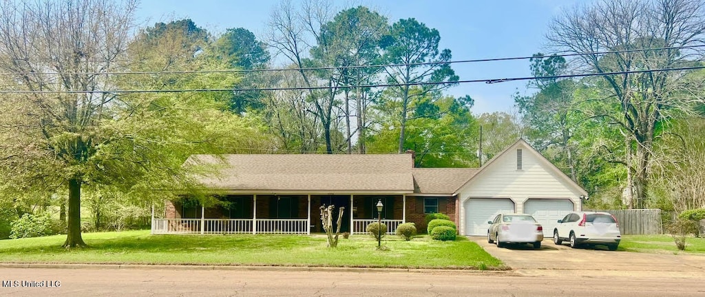 ranch-style house featuring a front lawn, a porch, and a garage