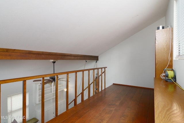 corridor featuring lofted ceiling, wood-type flooring, and an upstairs landing