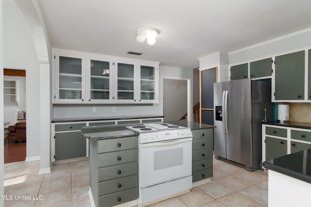 kitchen with dark countertops, electric stove, and stainless steel fridge with ice dispenser