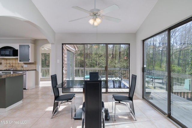 dining area with lofted ceiling, ceiling fan, baseboards, and light tile patterned floors