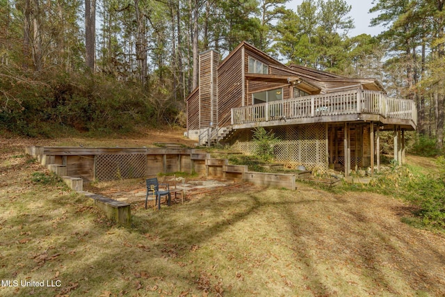 back of house featuring a deck, a chimney, and stairway