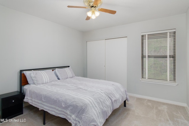 carpeted bedroom with a closet, ceiling fan, and baseboards