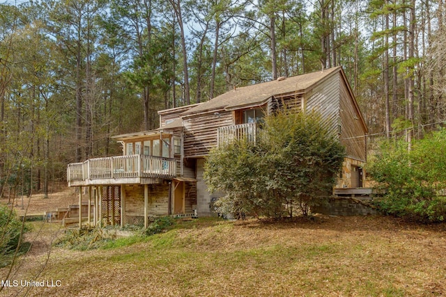 back of property featuring stairs and a deck