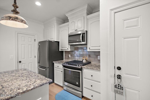 kitchen with white cabinetry, appliances with stainless steel finishes, tasteful backsplash, hanging light fixtures, and light stone countertops