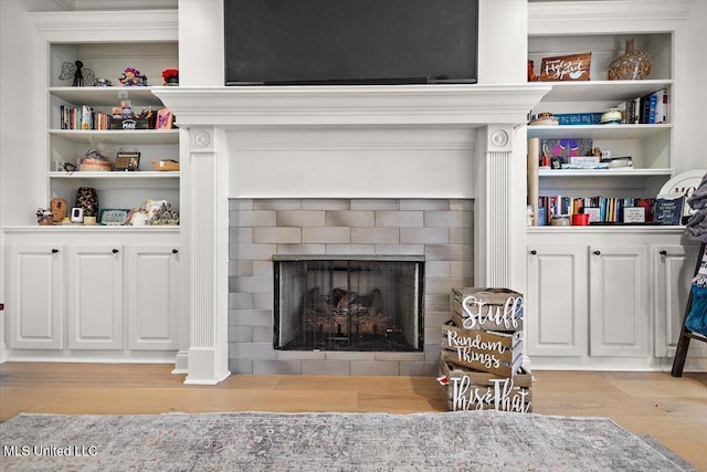 living room with light hardwood / wood-style flooring and built in shelves