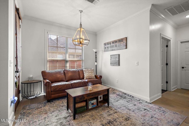 living room featuring wood-type flooring, ornamental molding, and a chandelier