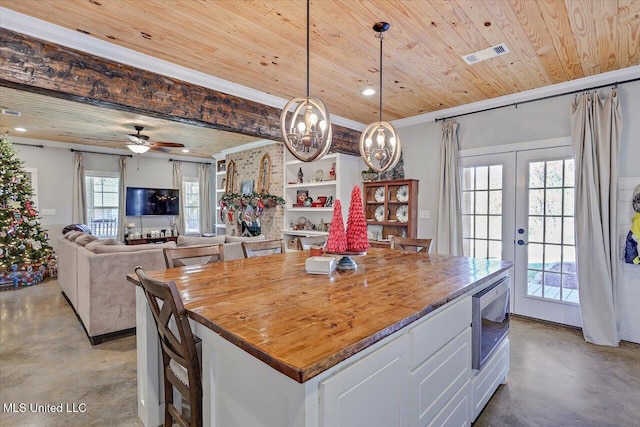 kitchen featuring visible vents, wood ceiling, finished concrete floors, built in microwave, and french doors