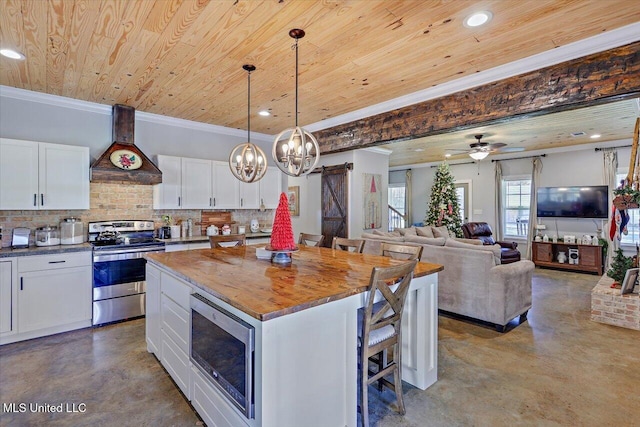 kitchen featuring finished concrete flooring, custom exhaust hood, stainless steel appliances, a barn door, and wooden ceiling