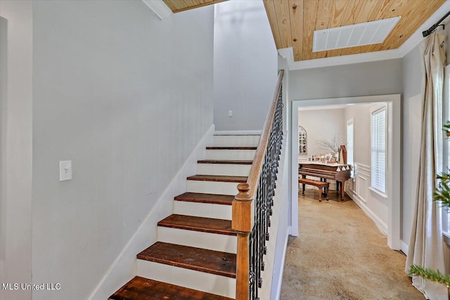 stairs with wood ceiling, visible vents, and ornamental molding