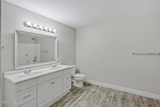 full bathroom with a shower, wood finished floors, a sink, and baseboards