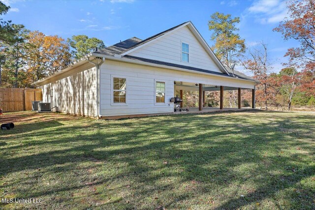 back of property featuring central AC unit, fence, a lawn, and a patio