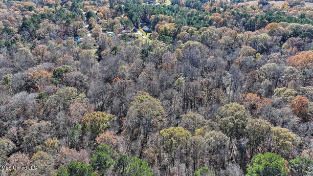 drone / aerial view featuring a wooded view