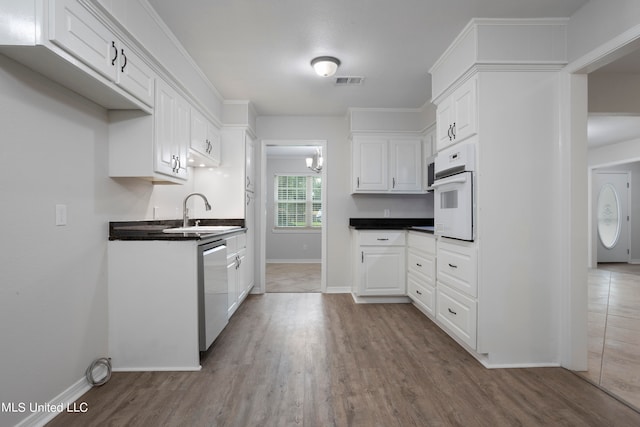 kitchen featuring sink, white oven, white cabinetry, stainless steel dishwasher, and light hardwood / wood-style flooring