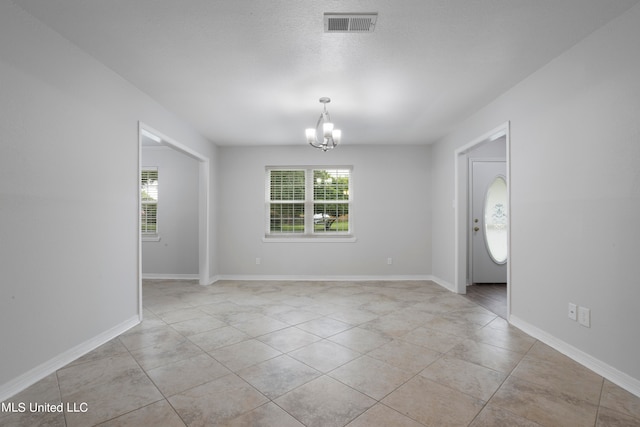 unfurnished room featuring light tile patterned floors and an inviting chandelier