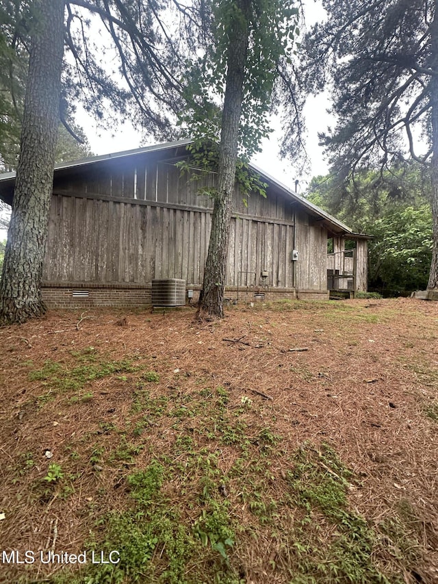 view of home's exterior featuring central air condition unit, board and batten siding, and crawl space