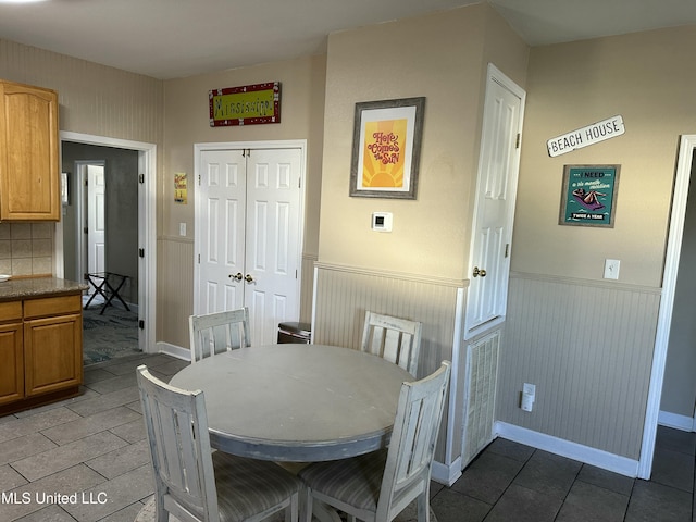 dining space featuring wainscoting