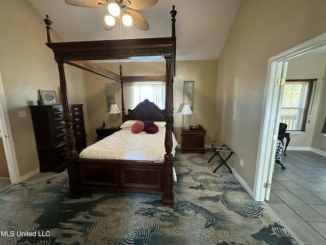 bedroom with multiple windows, baseboards, and lofted ceiling