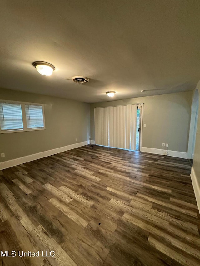 unfurnished room featuring dark wood-type flooring