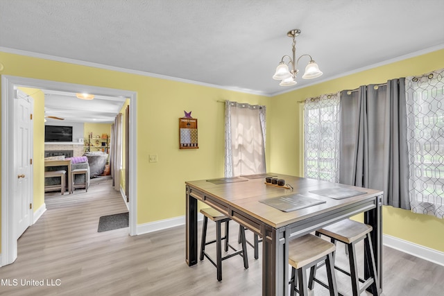 112 Rolling Meadows Dr, Jackson, MS 39211 - dining space featuring healthy amount of natural light, a chandelier, a fireplace, light wood finished floors, and crown molding