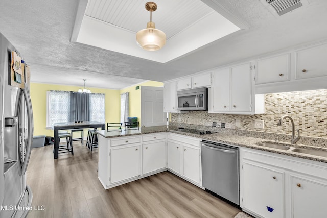 112 Rolling Meadows Dr, Jackson, MS 39211 - kitchen featuring appliances with stainless steel finishes, a raised ceiling, light wood-style floors, a sink, and white cabinetry