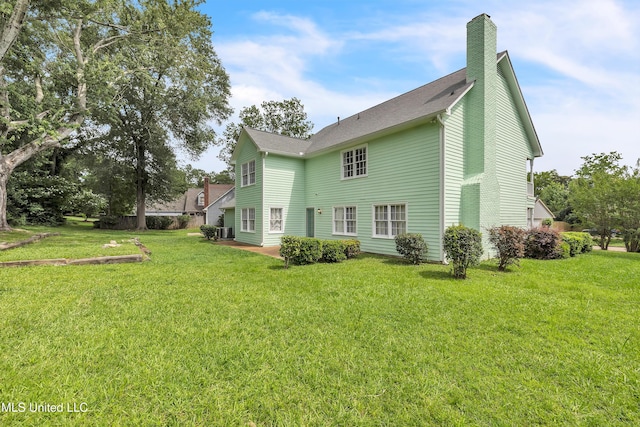 112 Rolling Meadows Dr, Jackson, MS 39211 - back of house featuring a chimney, a lawn, roof with shingles, central AC, and a patio