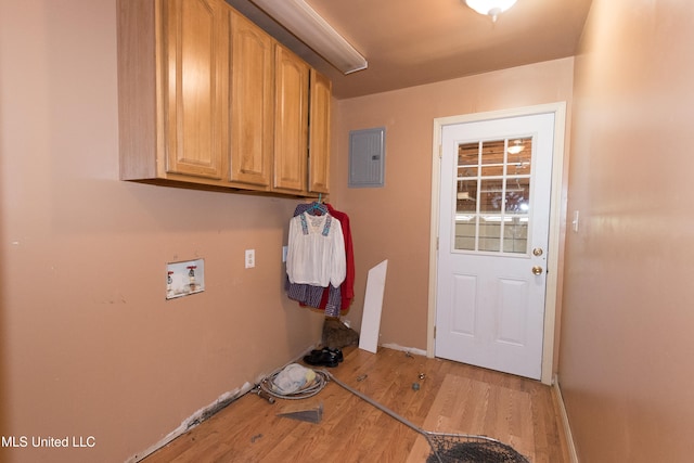 washroom with electric panel, washer hookup, cabinets, and light wood-type flooring