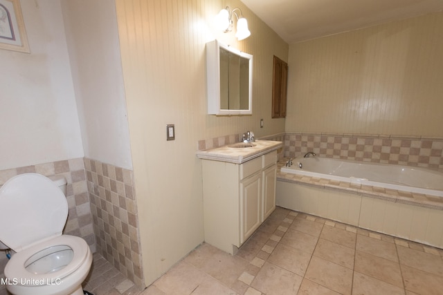 bathroom with toilet, vanity, tile patterned floors, and tiled bath