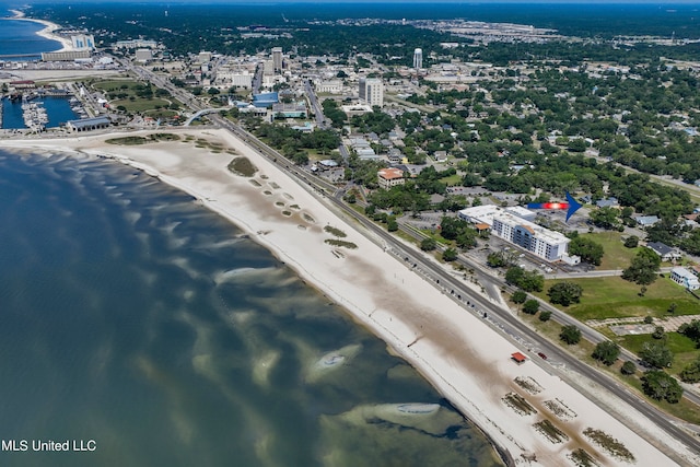 birds eye view of property with a water view and a beach view