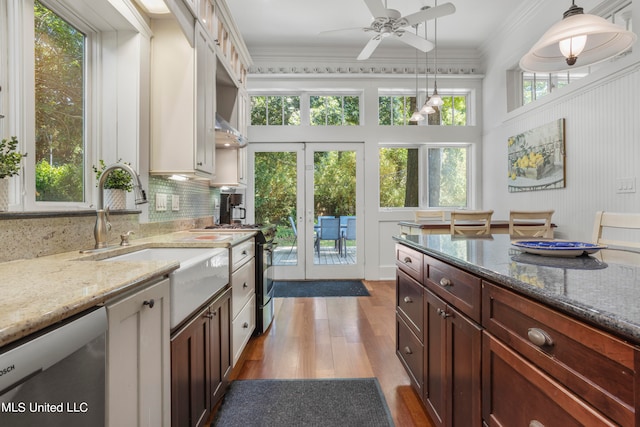 kitchen featuring ornamental molding, decorative light fixtures, white cabinetry, appliances with stainless steel finishes, and light hardwood / wood-style floors