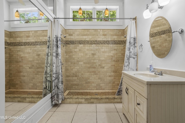 full bath with vanity, tile patterned flooring, and tiled shower